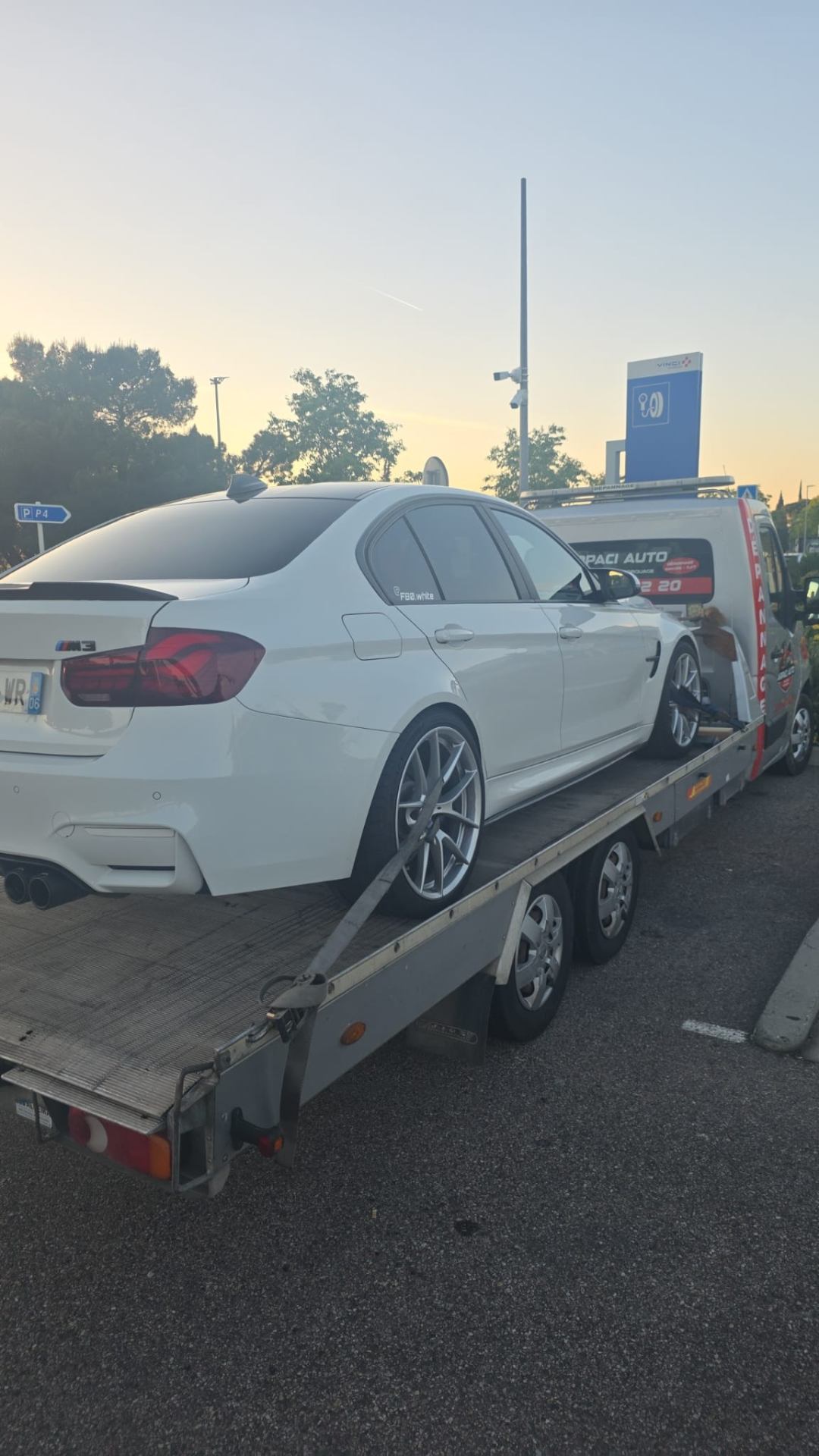 Remorquage d'une BMW M3 blanche sur aire d'autoroute